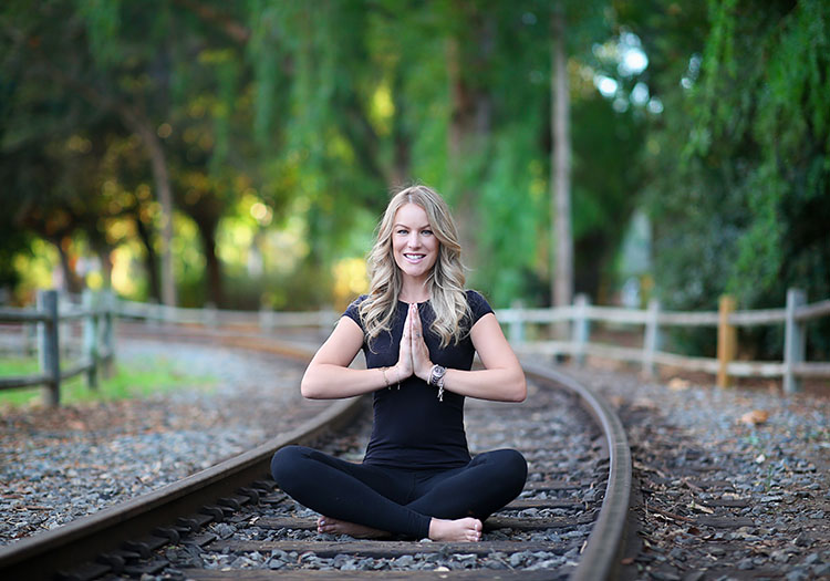Julia Kay seated cross-legged on railway tracks